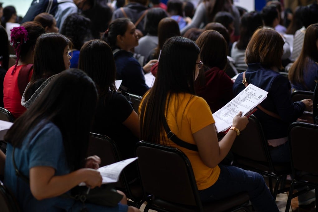 Migrant workers sit waiting with their documents at the Philippine Trade Training Centre in the Philippines. The medical journal Lancet Psychiatry has found that domestic workers are particularly vulnerable and their mental health could worsen as the coronavirus outbreak continues. Photo: Bloomberg