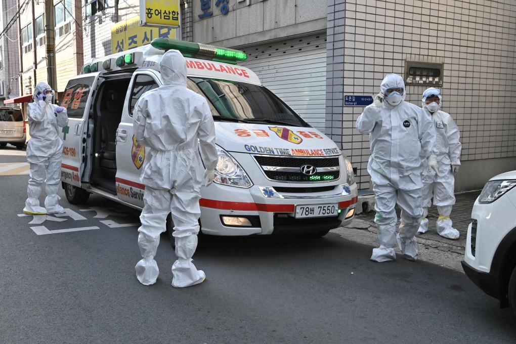 South Korean medical workers visit a building to take samples from residents suspected to have the Covid-19 disease. Photo: AFP