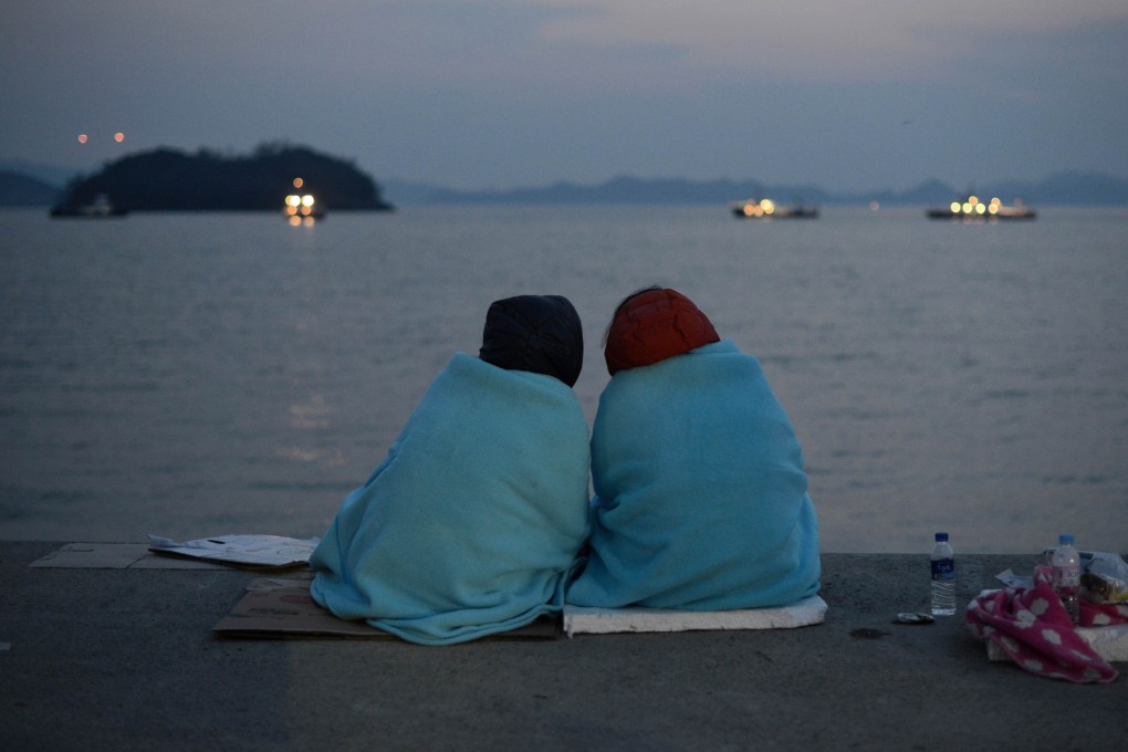 Relatives of victims of the sinking of the South Korean ferry Sewol sit at Jindo harbour as divers search for bodies. Photo: AFP