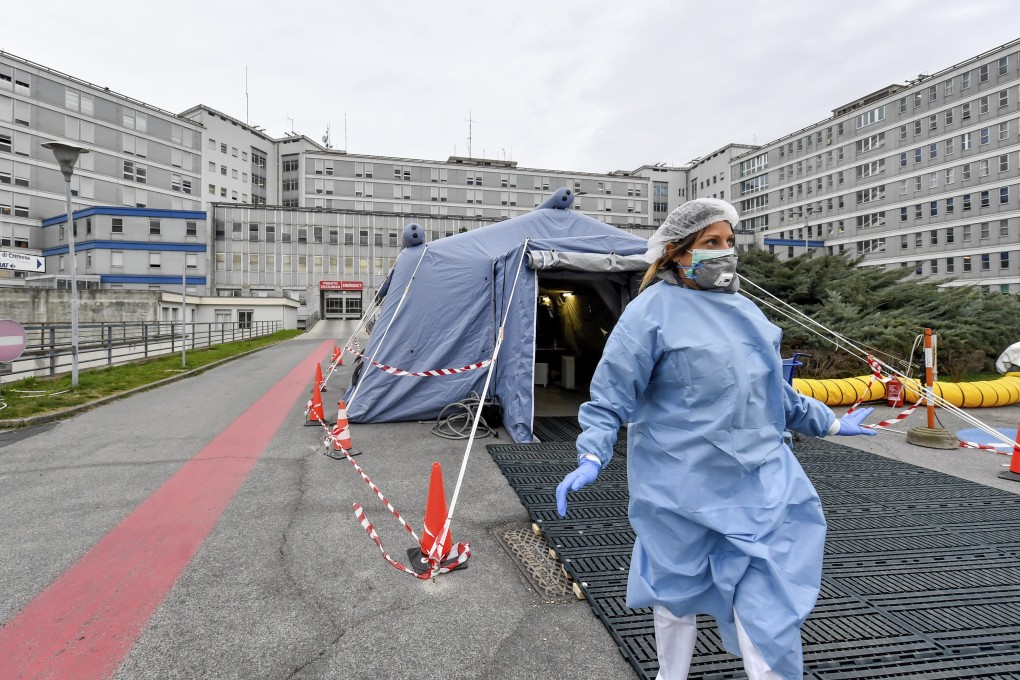 A paramedic walks out of a tent that was set up in front of the emergency ward of the Cremona hospital, northern Italy. Photo: Lapresse via AP