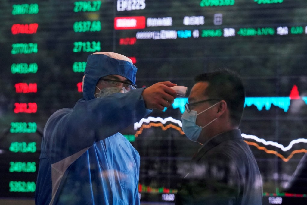 A worker wearing a protective suit takes body temperature measurement of a man inside the Shanghai Stock Exchange building on February 28. Even before the coronavirus scare, it had already begun to look like a question of when, rather than if, a debt crisis would erupt. All that was missing was the “trigger”. Photo: Reuters