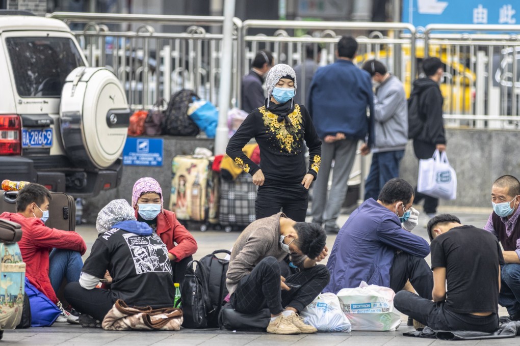 Uygurs wearing face masks pictured outside a railway station in Guangzhou last month. Photo: EPA