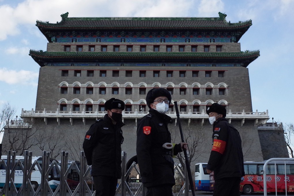 Security officers wearing protective masks stand guard in front of the arrow tower in the Qianmen area of Beijing on March 1. Photo: EPA-EFE