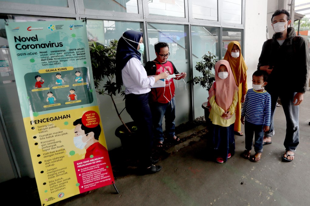 A commuter line medical officer provides masks to passengers at the Depok Baru Train Station in Depok, West Java, Indonesia. Photo: EPA-EFE