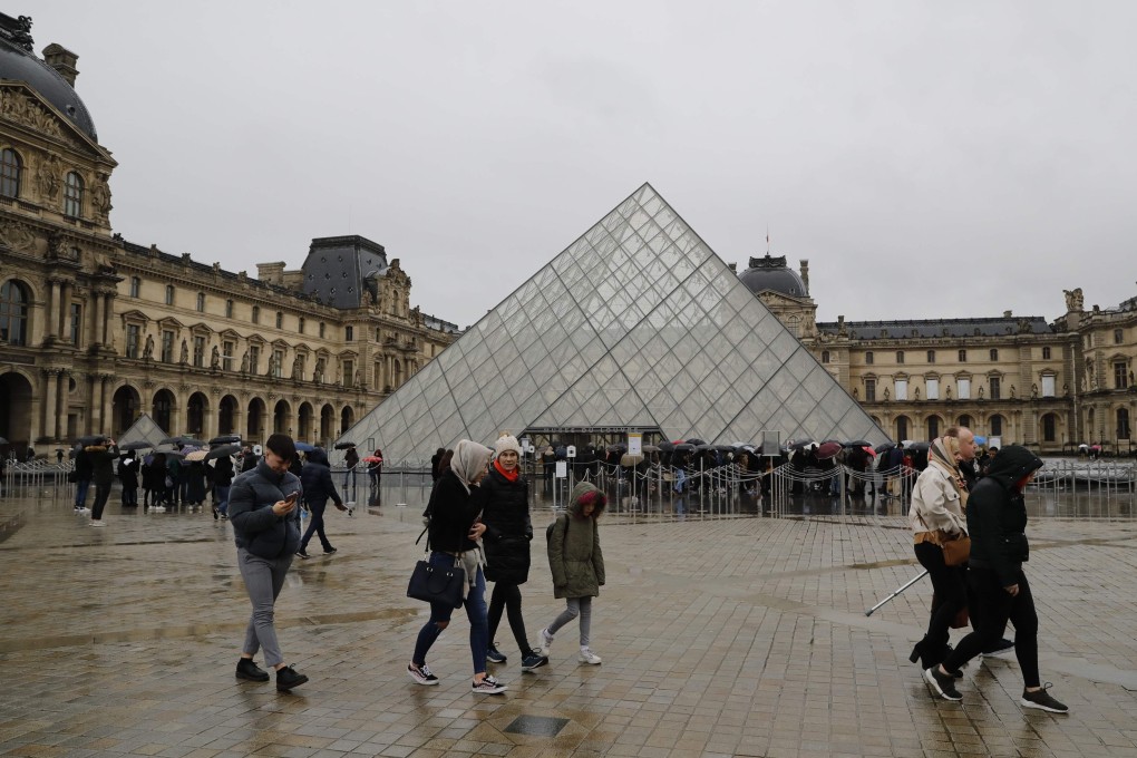 People wait in front of the Louvre Pyramide in Paris on March 1. Photo: AFP