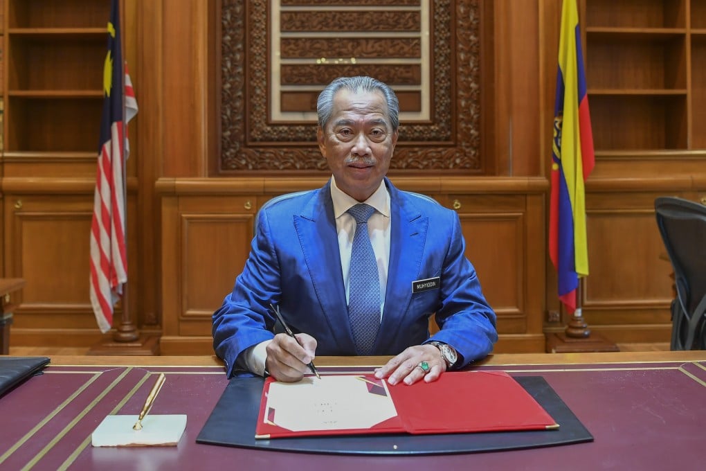 Malaysian Prime Minister Muhyiddin Yassin signs a document on his first day at the Prime Minister's office. He was sworn in on Sunday. Photo: DPA
