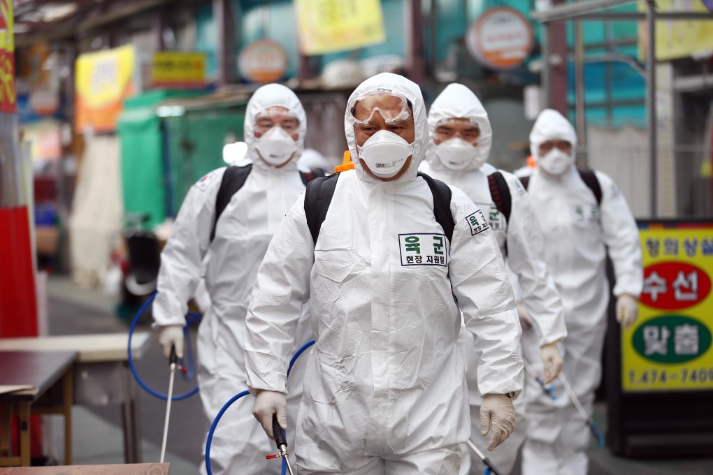 South Korean soldiers wearing protective gear spray disinfectant at a market in Daegu. Photo: AFP
