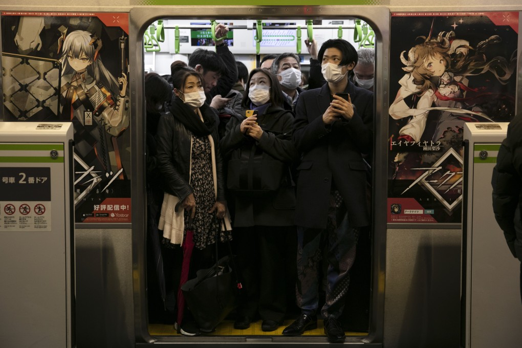 Commuters wearing masks stand in a packed train at Shinagawa Station in Tokyo on Monday. Photo: AP