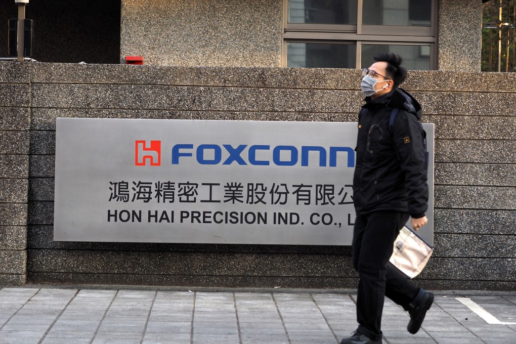 A man wearing a face mask walks past the logo of Foxconn Technology Group, formally known as Hon Hai Precision Industry, in New Taipei City, Taiwan, on February 18. Photo: EPA-EFE