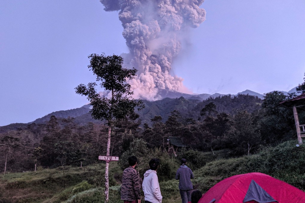 Tourists watch as Mount Merapi volcano erupts. Photo: Reuters