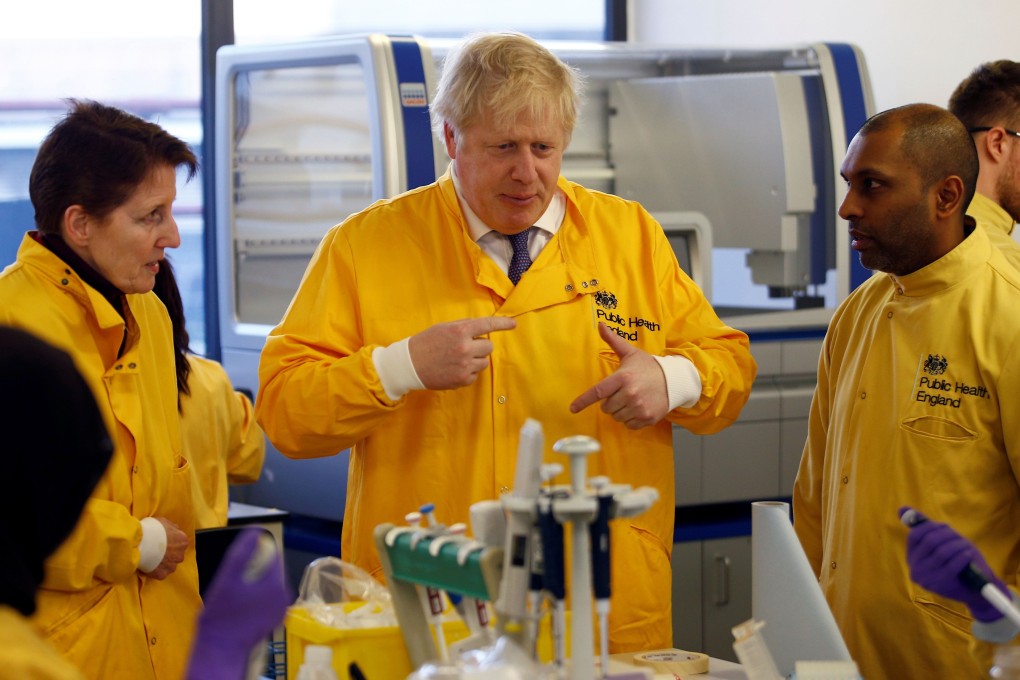 British Prime Minister Boris Johnson (centre) meets with laboratory staff at the Public Health England National Infection Service in London on Sunday. Photo: AFP