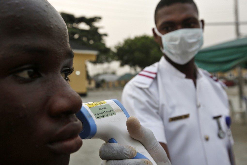 A Nigerian army health official performs a temperature check on a hospital visitor in Lagos on Friday. Photo: Bloomberg