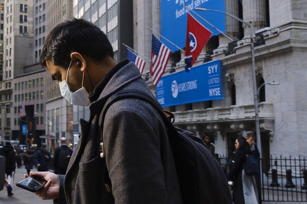 A man wearing a face mask walks past the New York Stock Exchange on Tuesday. Photo: EPA-EFE