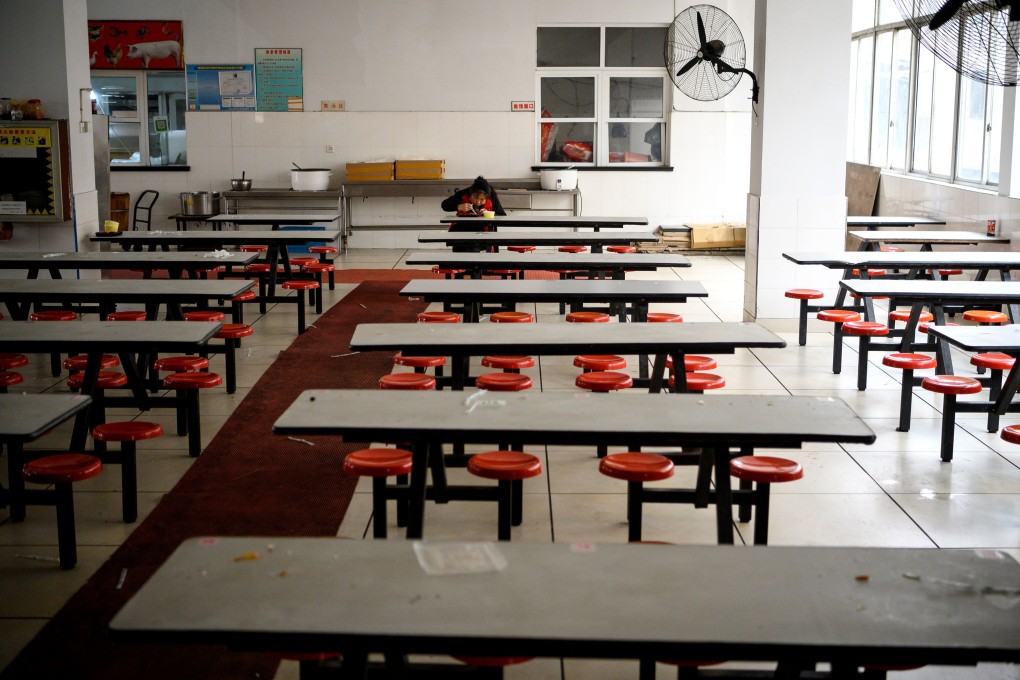 A lone worker eats during lunch break at a factory canteen in Wenzhou, China, on February 27. China is working to get its factories and its economy back up and running. Photo: AFP