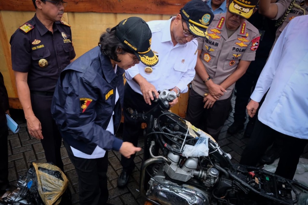 Indonesia’s Finance Minister Sri Mulyani Indrawati inspects seized parts of luxury cars during a raid in Jakarta. Photo: AFP