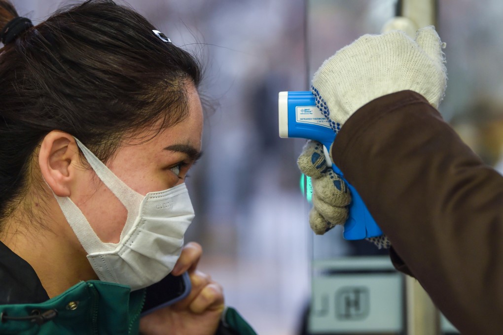 A customer has her temperature checked as she enters a supermarket in Shanghai. Photo: AFP