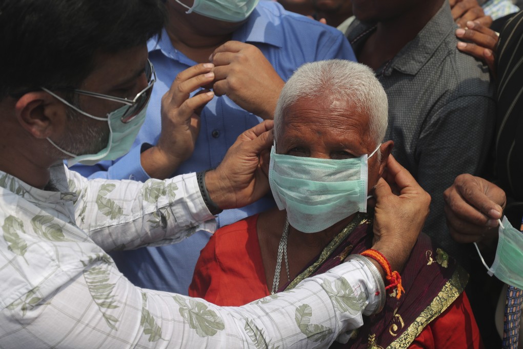 An Indian social activist distributes face masks to pedestrians in Hyderabad after a tech worker who passed through the city was confirmed to have contracted the new coronavirus, which causes Covid-19. Photo: AP