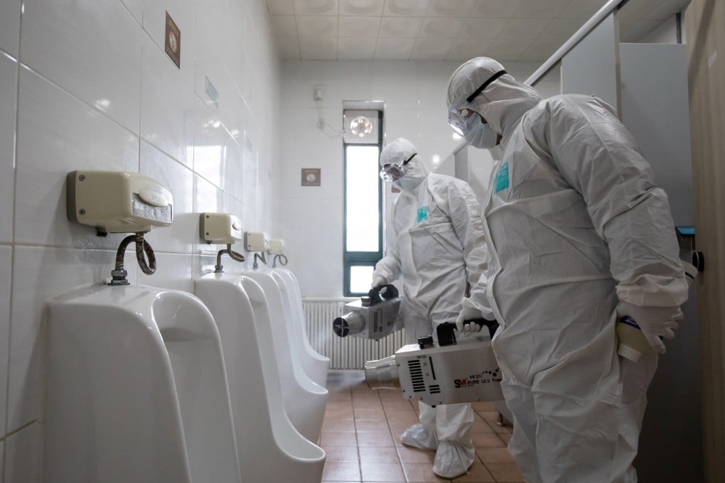 Staff spray disinfectant inside a toilet at a bus depot in Seoul, South Korea. Photo: Bloomberg