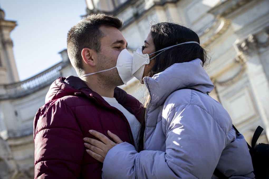 Two people wearing face masks kiss in Rome on Wednesday. Photo: EPA-EFE