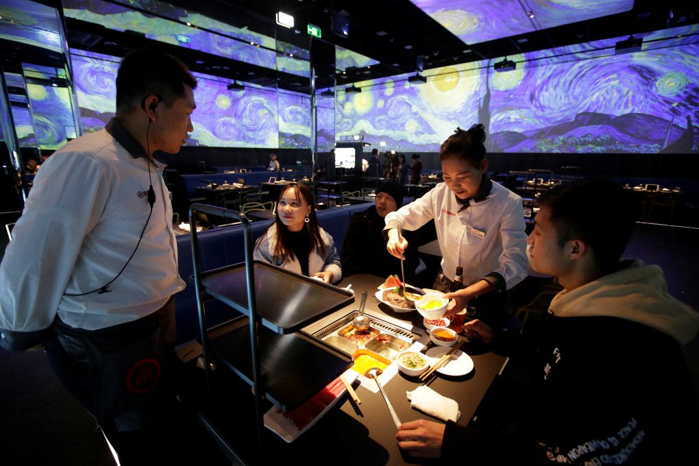A waiter serves diners at a Haidilao's artificial intelligence hotpot restaurant in Beijing in November 2018. Photo: Reuters