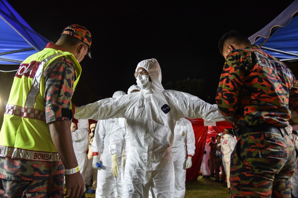 Health workers wearing protective suits as the second batch of Malaysian nationals, evacuated from the Chinese city of Wuhan, the epicentre of the Covid-19 novel coronavirus outbreak, arrived at Kuala Lumpur International Airport on February 26. Photo: Handout