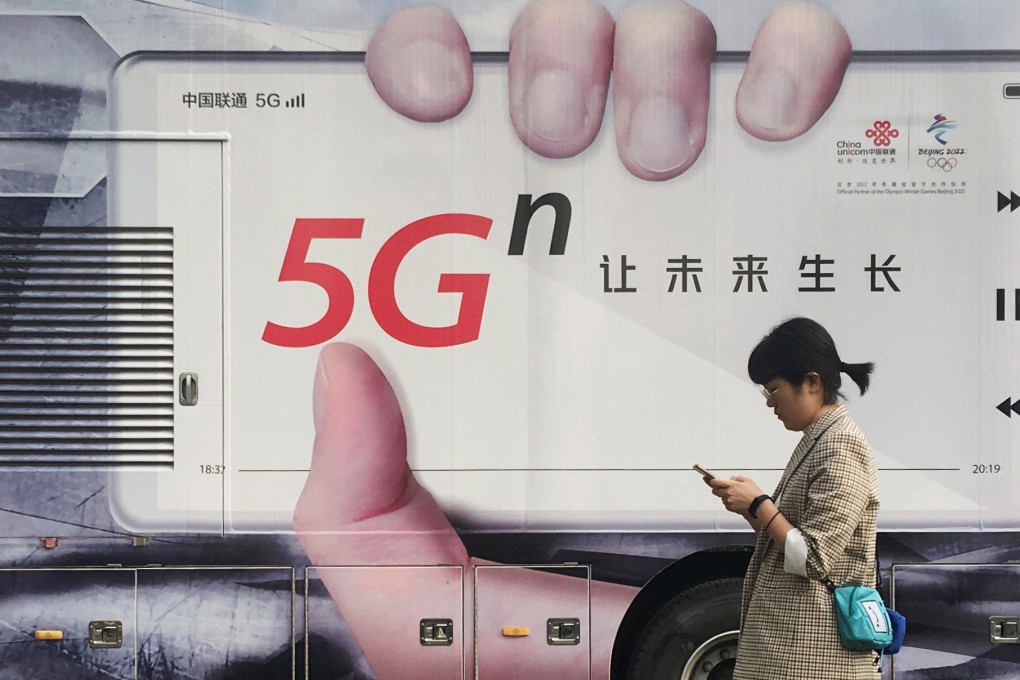 A woman using her smartphone walks past a vehicle covered with a China Unicom 5G advertisement in Beijing in September of last year. China is expected to have 600 million 5G users by 2025. Photo: Reuters