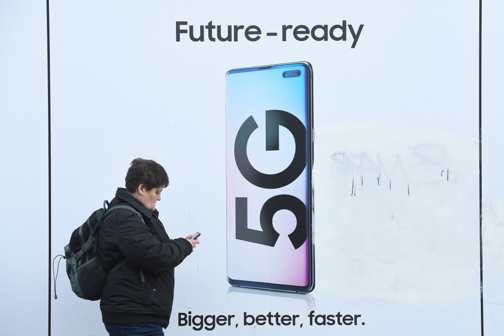 A pedestrian walks past an advertisement displaying a 5G device in London on January 29. Photo: EPA-EFE