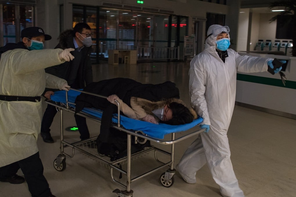 Volunteers take a pregnant woman into the Wuhan Maternal and Child Health Hospital to be tested for the coronavirus. Photo: Xinhua