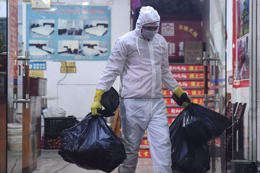 A staff member transfers garbage generated inside an isolation area in Du'an Yao Autonomous County, south China's Guangxi Zhuang Autonomous Region. Photo: Xinhua/Cao Yiming