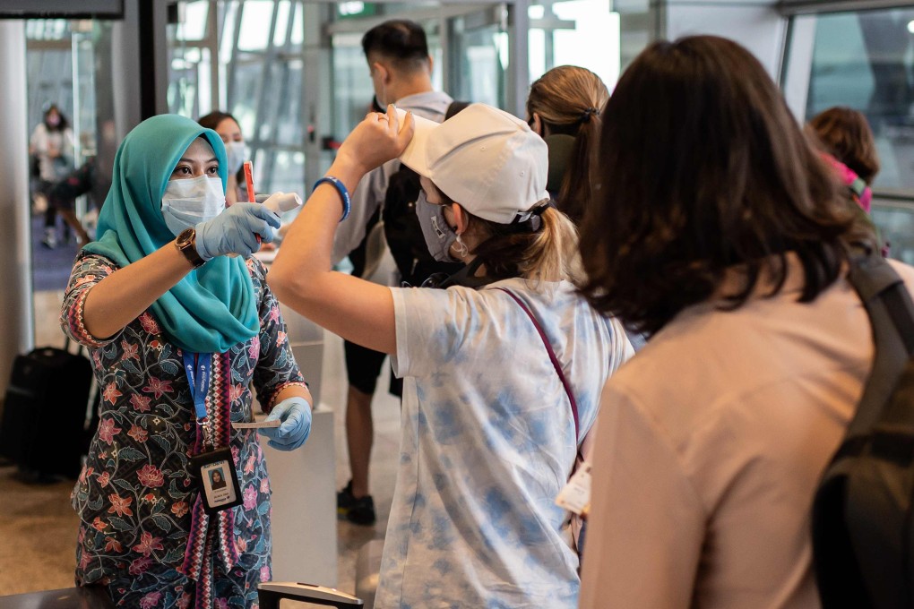 A worker checks the temperature of passengers at the Kuala Lumpur International Airport on February 14, 2020. Photo: AFP