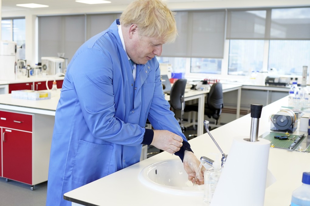 British Prime Minister Boris Johnson washes his hands during his visit to Mologic Laboratory in Bedford, Britain. Photo: Xinhua