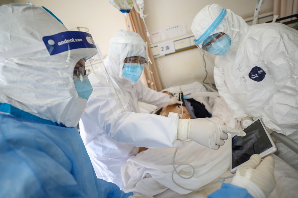 Medical workers in protective suits attend to a patient inside an isolated ward of Wuhan Red Cross Hospital. Photo: Reuters