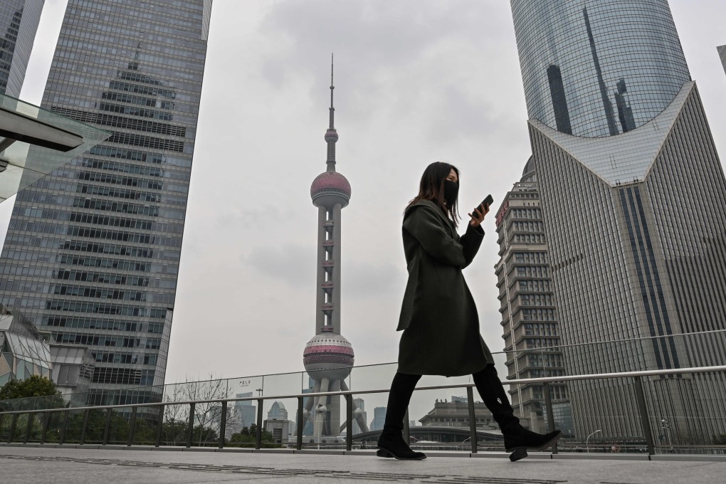 A woman wears a face mask in Shanghai’s financial district. Major shopping districts in China’s commercial and financial capital remain deserted. Photo: AFP