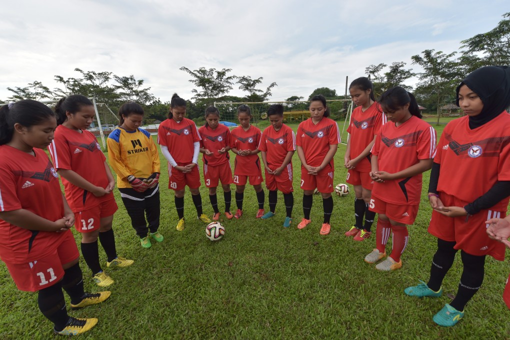 Members of CSC Women Soccer Indonesia pray during a training session in Jakarta. Women’s football in Indonesia is gaining in popularity, but there is still much to be done to make it as big as the men’s game. Photo: AFP via Getty Images