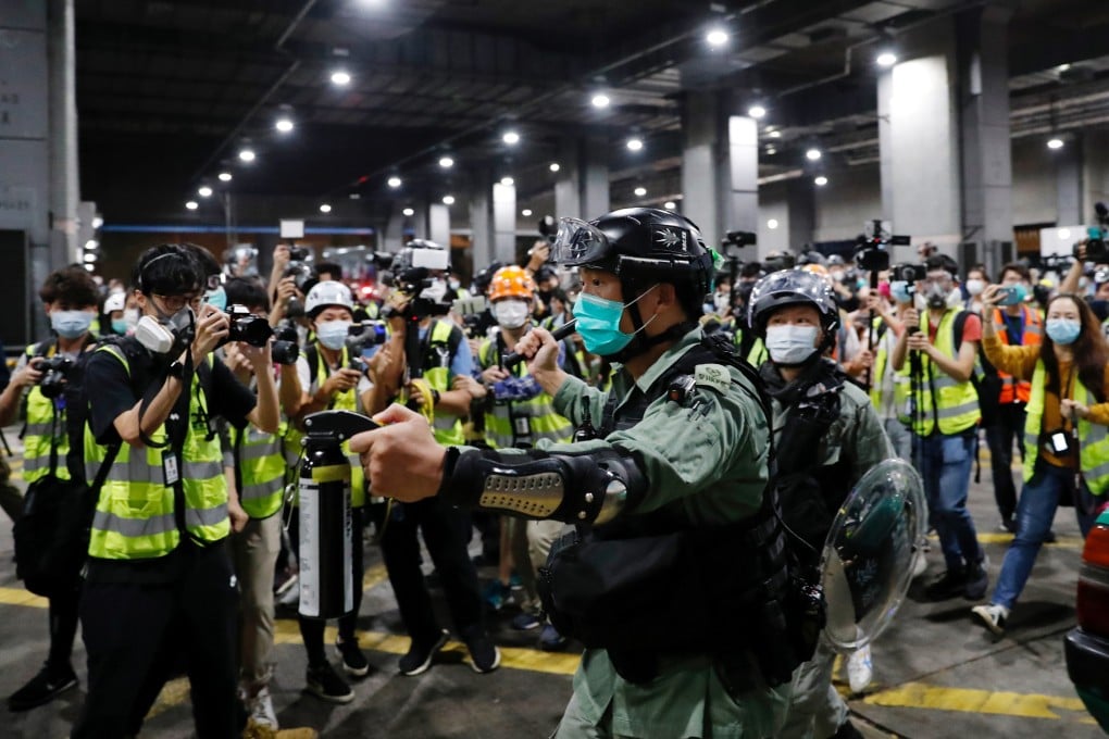 A police officer holds pepper spray as he tries to disperse anti-government protesters in Tseung Kwan O on Sunday. Photo: Reuters