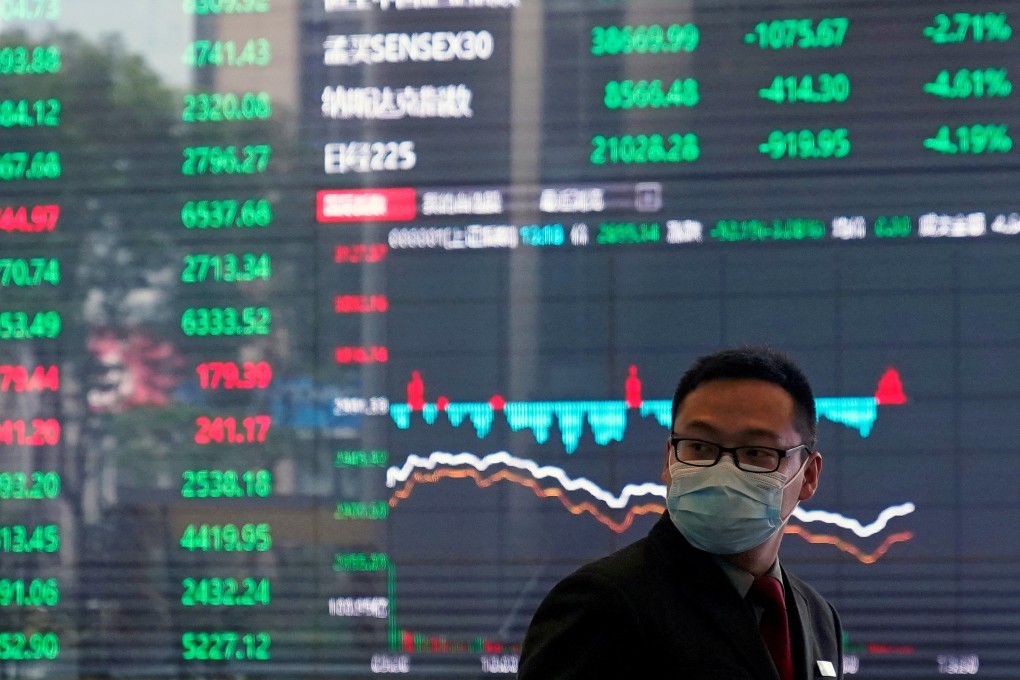 A man with a mask inside the Shanghai Stock Exchange building at the Pudong financial district in Shanghai on February 28, 2020. Contrary to global conventions, China’s stock market represents losses and declines in green, using the colour red to denote advances and gains. Photo: Reuters