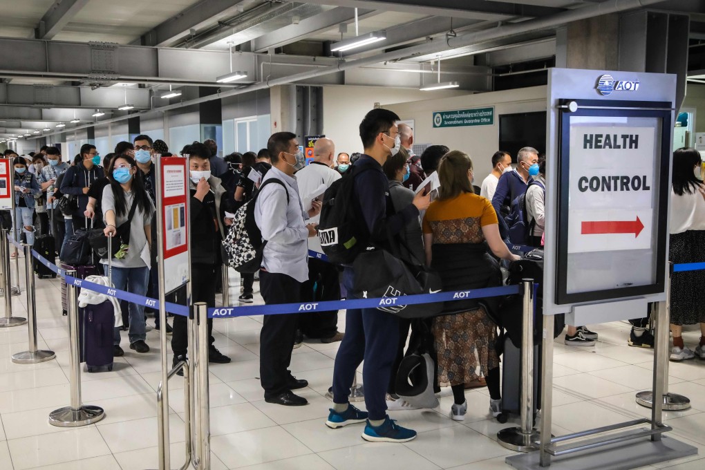 Incoming passengers from coronavirus ‘danger zones’ queue up to have their temperatures taken and health assessed at an airport in Bangkok. Photo: AFP