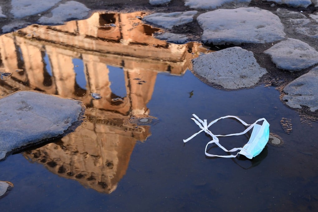 A discarded mask in a puddle at the Colosseum in Rome. Italy is reeling from a surge in infections. Photo: AP
