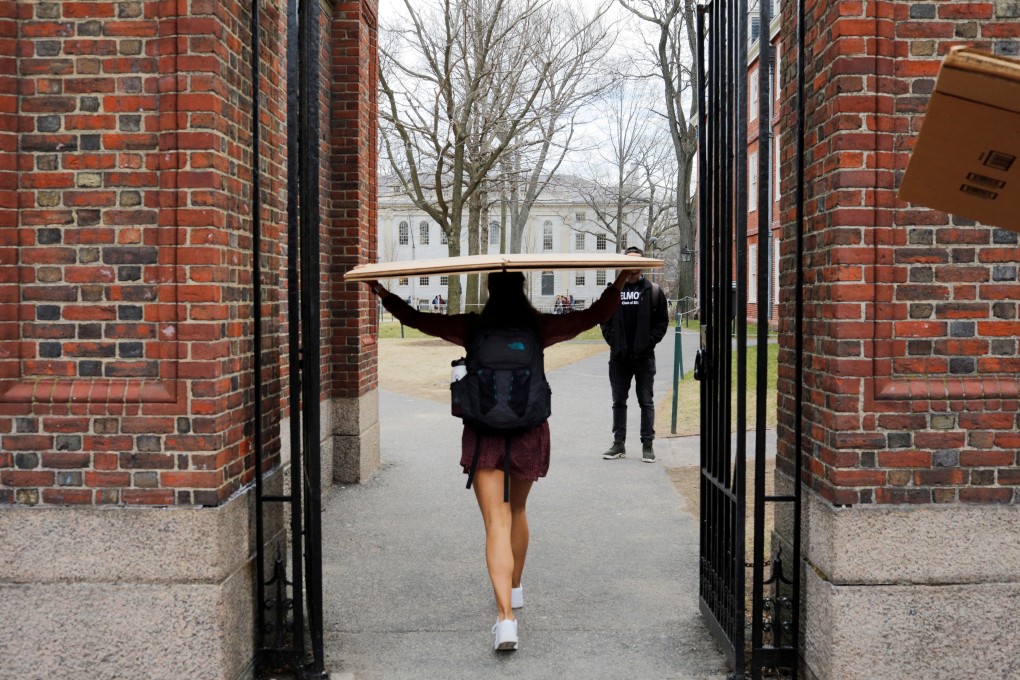 A student carries a box to her dorm at Harvard University on Tuesday, after the school asked its students not to return to campus after spring break. Photo: Reuters