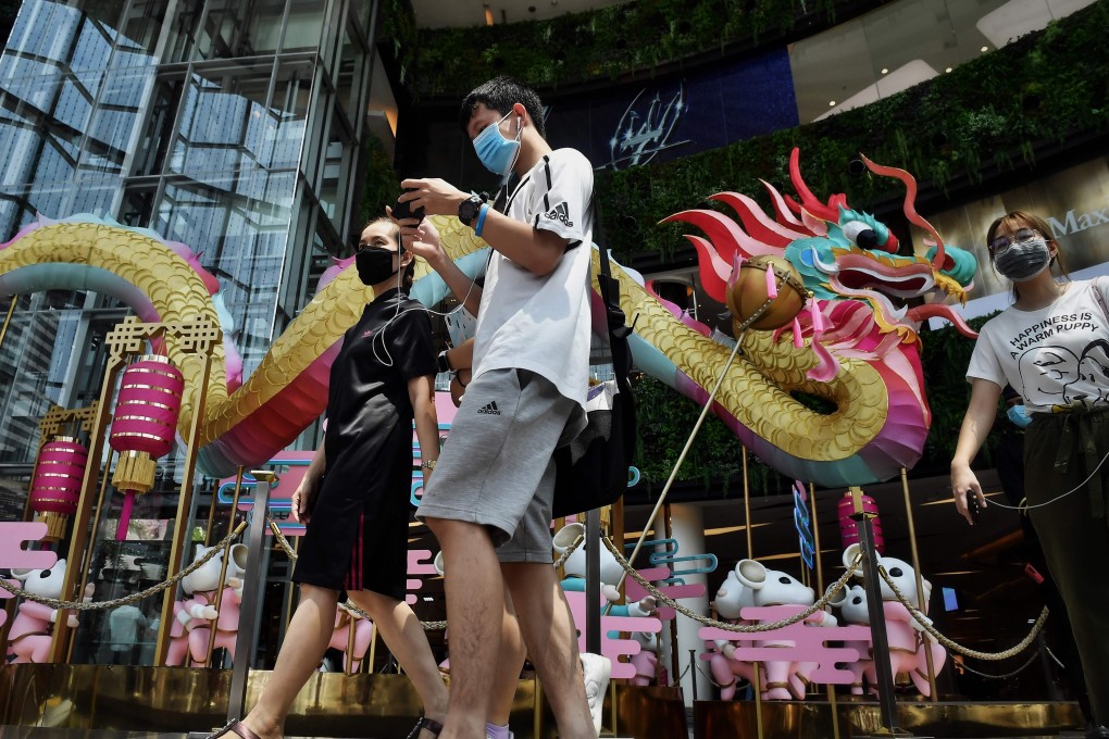 People wearing face masks amid concerns over the spread of Covid-19 walk through a Bangkok shopping centre. Photo: AFP