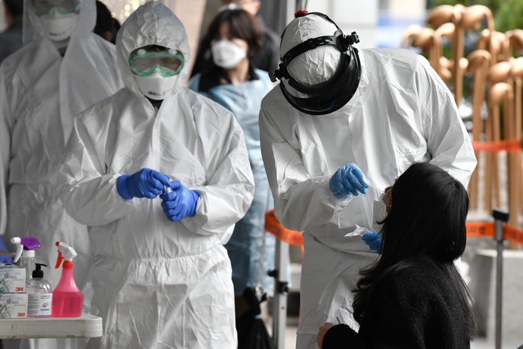 Health workers wearing protective gear take samples from employees at a building in Seoul where 46 people were confirmed to have the Covid-19 coronavirus. Photo: AFP