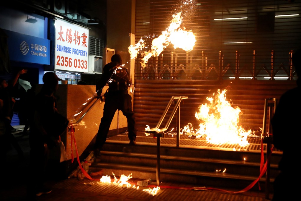 A protester throws a Molotov cocktail at an MTR station entrance in Hong Kong. Photo: Reuters