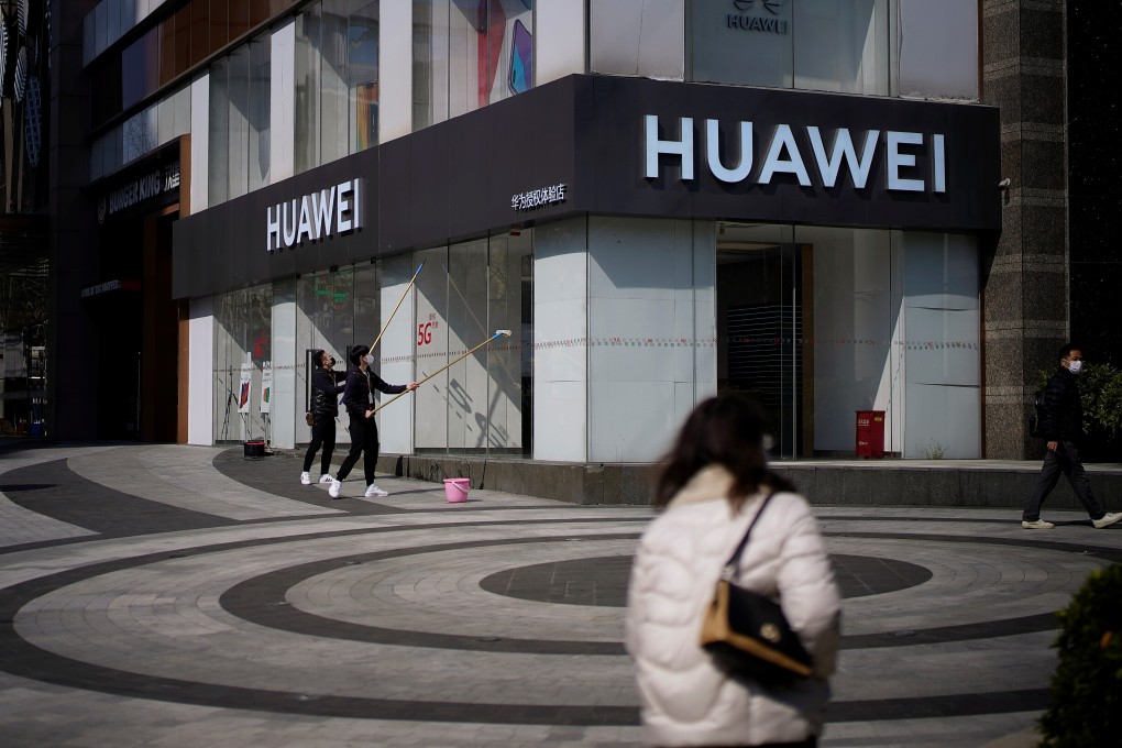 Workers clean the outside of a Huawei shop in Shanghai on Thursday. Photo: Reuters
