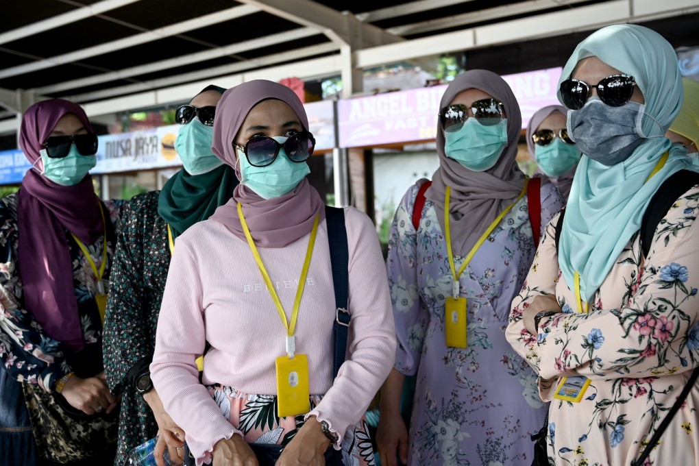 Passengers wearing face masks prepare to board fast boats bound for the Indonesian island of Nusa Penida. Photo: AFP