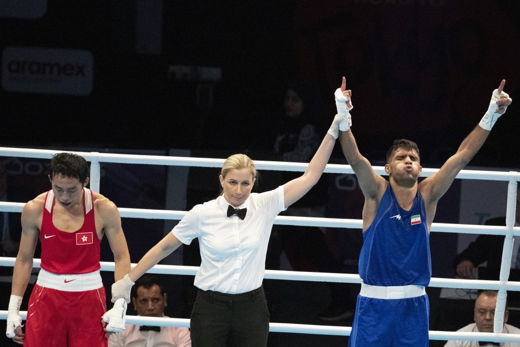 Iran’s Daniyal Shabakhsh raises his arms in triumph after winning his men's featherweight bout against a forlorn looking Rex Tso in Amman. Photo: EPA