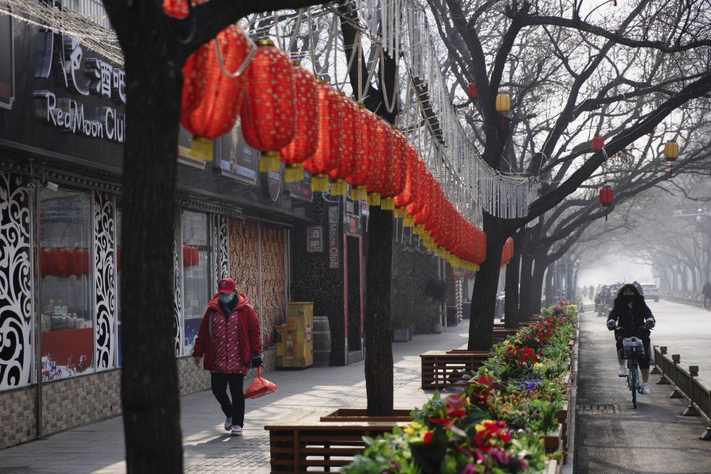 A woman walks past shuttered bars in Beijing, China. Photo: AP