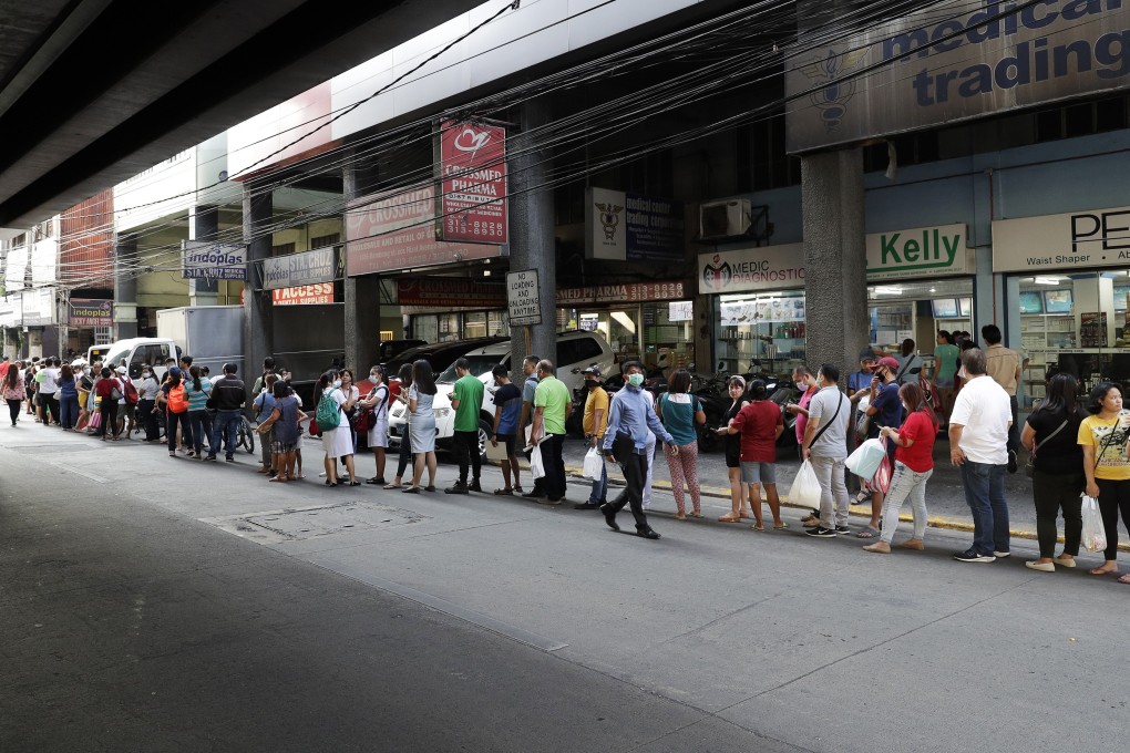 People queue to buy protective face masks at a store in Manila. Photo: AP