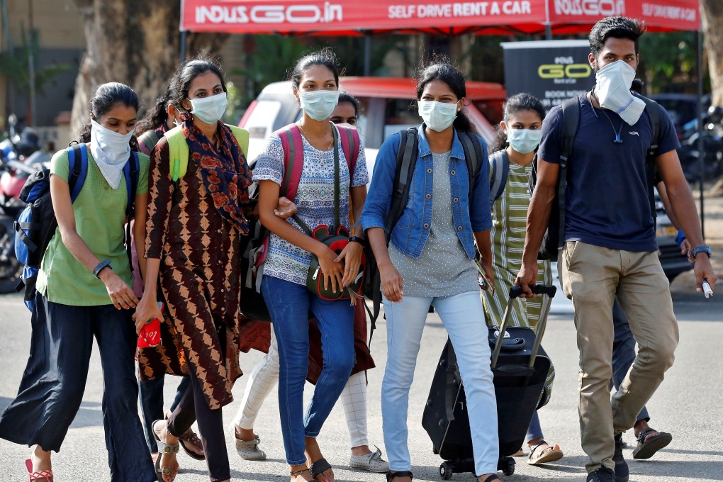 A group of students in protective masks walk outside a railway station in Kochi on March 10, 2020. Photo: Reuters