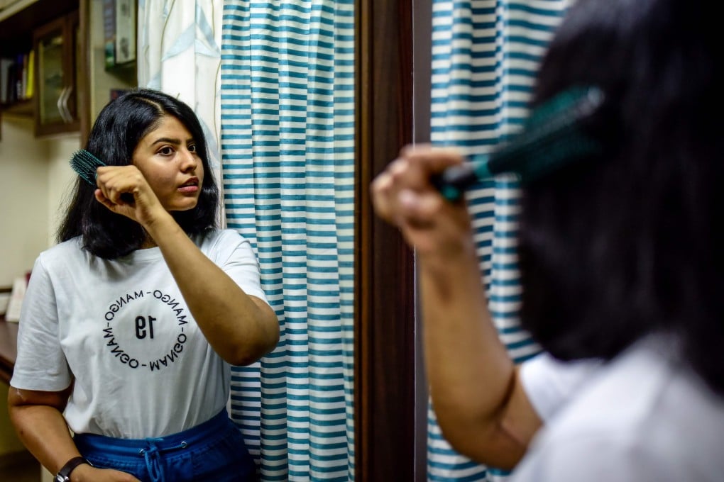 Shreya Siddanagowder brushes her hair in a bathroom at her home in Pune, more than two years after transplant surgery for both hands. Photo: AFP