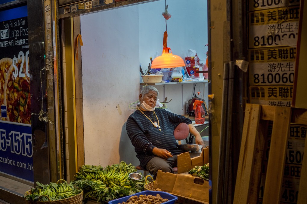 A hawker with his mask pulled down rests in a store in Prince Edward on February 15. Photo: Nathan Tsui